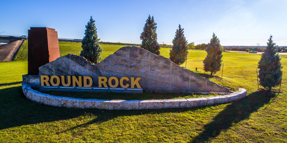 Open field with welcome sign to Round Rock , Texas